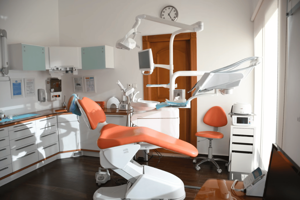 A dental office with an orange and white chair.