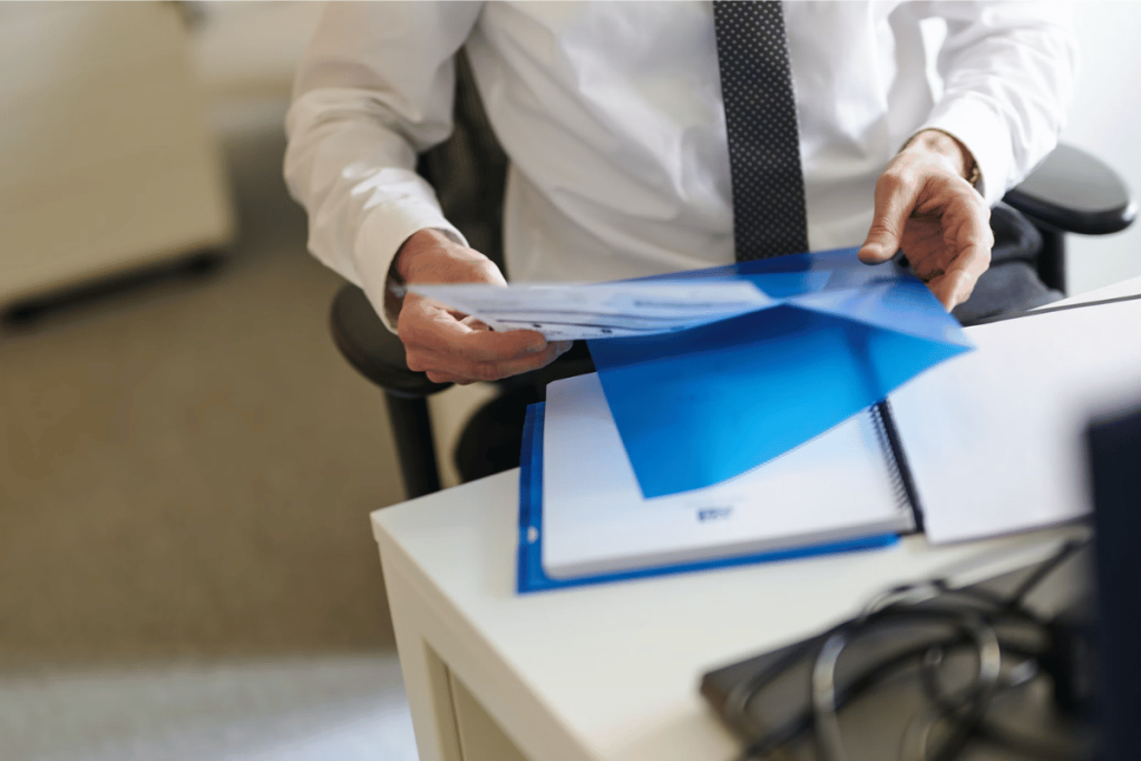 A person in a business suit is holding a folder.