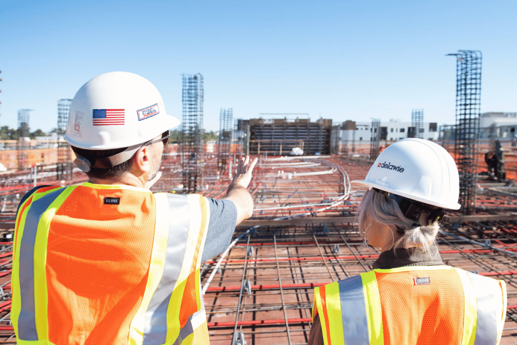 Two construction workers standing on a construction site.