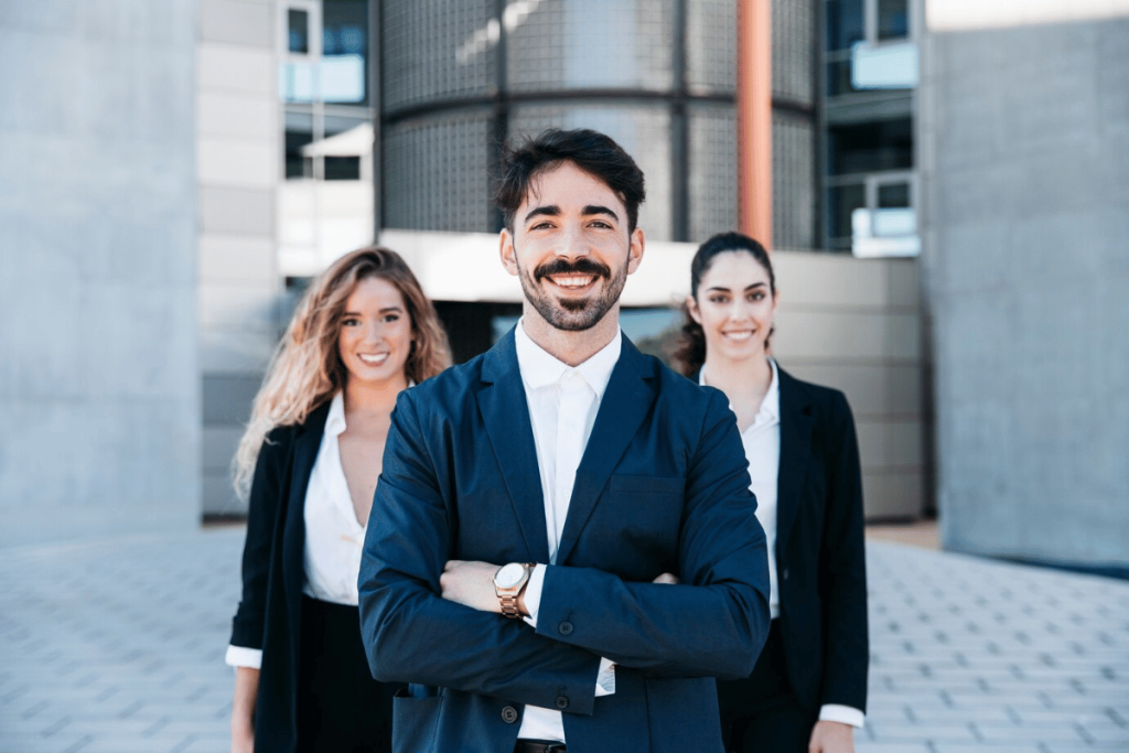 Three business people standing in front of a building.