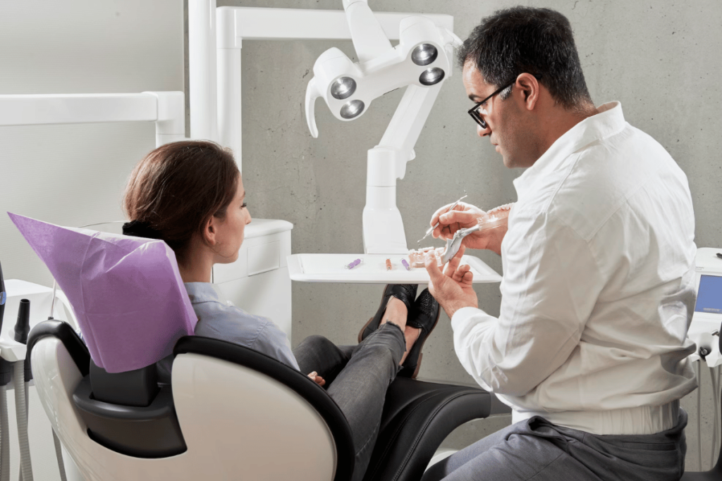 A person and another person sitting in a dental chair.