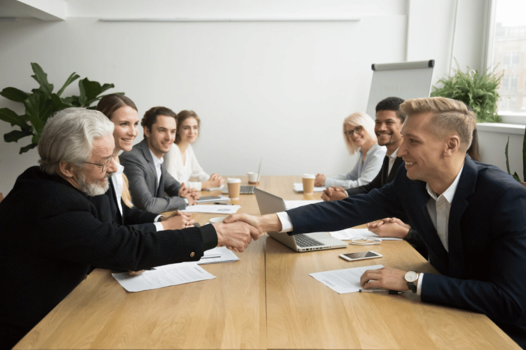 A group of business people shaking hands at a meeting.